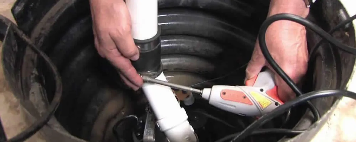 Sump pump installation technician connecting PVC discharge piping in Evansville, IN